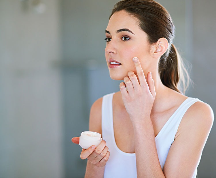 Dark Hair Woman Applying Cream on Face 1